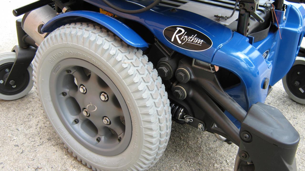 Close-up of a blue power wheelchair in the original rental collection