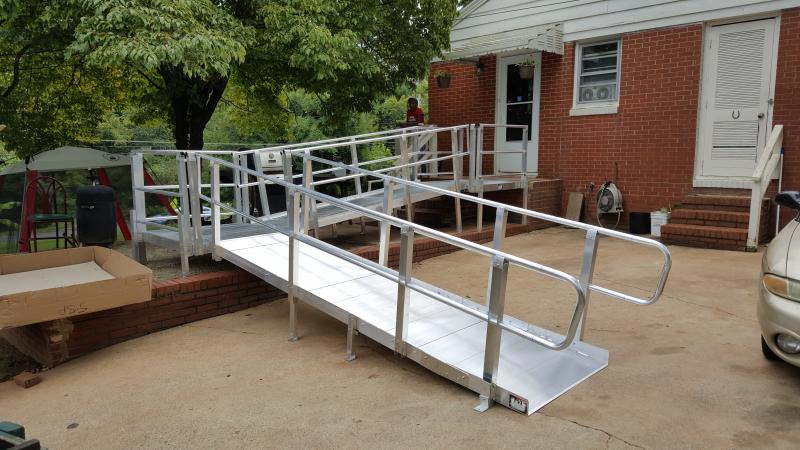 Original modular ramp with handrails leading to a brick home
